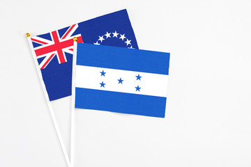 Honduras and Cook Islands stick flags on white background. High quality fabric, miniature national flag. Peaceful global concept.White floor for copy space.