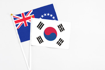 South Korea and Cook Islands stick flags on white background. High quality fabric, miniature national flag. Peaceful global concept.White floor for copy space.