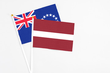 Latvia and Cook Islands stick flags on white background. High quality fabric, miniature national flag. Peaceful global concept.White floor for copy space.