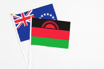 Malawi and Cook Islands stick flags on white background. High quality fabric, miniature national flag. Peaceful global concept.White floor for copy space.