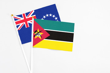 Mozambique and Cook Islands stick flags on white background. High quality fabric, miniature national flag. Peaceful global concept.White floor for copy space.