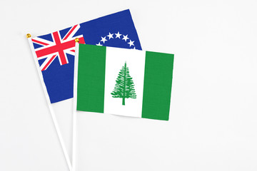 Norfolk Island and Cook Islands stick flags on white background. High quality fabric, miniature national flag. Peaceful global concept.White floor for copy space.