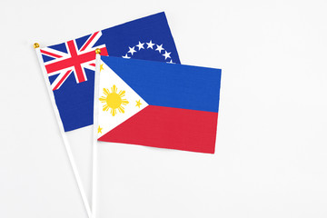 Philippines and Cook Islands stick flags on white background. High quality fabric, miniature national flag. Peaceful global concept.White floor for copy space.