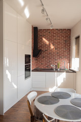 Kitchen - dining room. Interior of a modern apartment. Bright sunlight from the window.