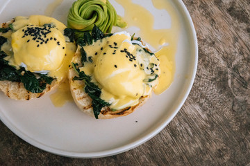 Close up top view Poached Egg with spinach, avocado and Bread Toast on wooden table. Healthy food and diet concept.