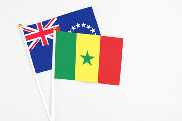 Senegal and Cook Islands stick flags on white background. High quality fabric, miniature national flag. Peaceful global concept.White floor for copy space.