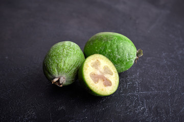 Green feijoa fruits on blue concrete background table. Tropical fruit feijoa. Set of ripe feijoa...