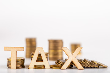 TAX inscription made of wooden letters on coin posts. Symbol of tax collection from the public.