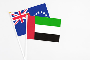 United Arab Emirates and Cook Islands stick flags on white background. High quality fabric, miniature national flag. Peaceful global concept.White floor for copy space.