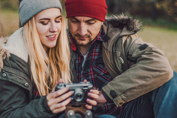 Travel couple camping with camera having fun in the forest. Concept of trekking, adventure and seasonal vacation.