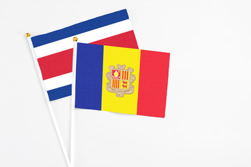 Andorra and Costa Rica stick flags on white background. High quality fabric, miniature national flag. Peaceful global concept.White floor for copy space.