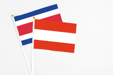 Austria and Costa Rica stick flags on white background. High quality fabric, miniature national flag. Peaceful global concept.White floor for copy space.
