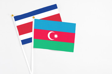 Azerbaijan and Costa Rica stick flags on white background. High quality fabric, miniature national flag. Peaceful global concept.White floor for copy space.