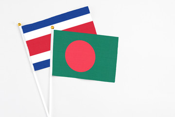 Bangladesh and Costa Rica stick flags on white background. High quality fabric, miniature national flag. Peaceful global concept.White floor for copy space.