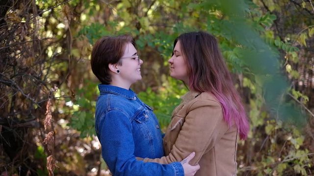 Charming young women kissing gently loving each other stroking touching face skin enjoying romantic tender moments on picnic date in the countryside.
