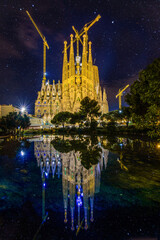 Gaudis Sagrada familia with reflections in the middle of Barcelona´s night sky