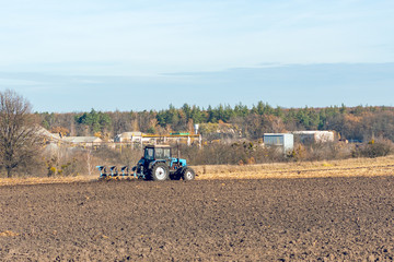 The tractor plows a field, cultivates the soil for sowing grain