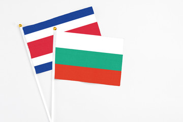 Bulgaria and Costa Rica stick flags on white background. High quality fabric, miniature national flag. Peaceful global concept.White floor for copy space.