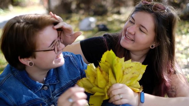Charming young women kissing gently loving each other stroking touching face skin enjoying romantic tender moments on picnic date in the countryside.
