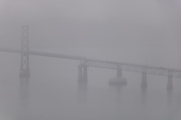 A bridge in a fog during a rainy day.