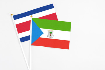 Equatorial Guinea and Costa Rica stick flags on white background. High quality fabric, miniature national flag. Peaceful global concept.White floor for copy space.