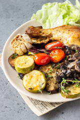 Baked chicken legs with vegetables and mushrooms with salad and thyme.