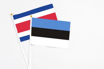 Estonia and Costa Rica stick flags on white background. High quality fabric, miniature national flag. Peaceful global concept.White floor for copy space.