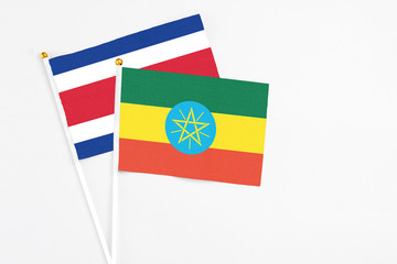 Ethiopia and Costa Rica stick flags on white background. High quality fabric, miniature national flag. Peaceful global concept.White floor for copy space.