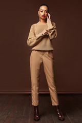 Beautiful sexy woman long brunette hair glamour model wear pants and sweater work office style...