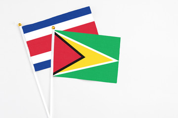 Guyana and Costa Rica stick flags on white background. High quality fabric, miniature national flag. Peaceful global concept.White floor for copy space.