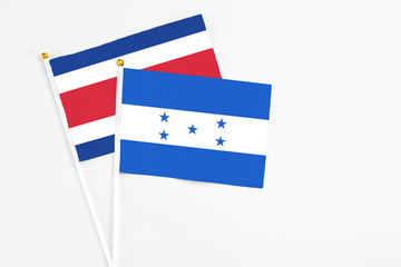 Honduras and Costa Rica stick flags on white background. High quality fabric, miniature national flag. Peaceful global concept.White floor for copy space.