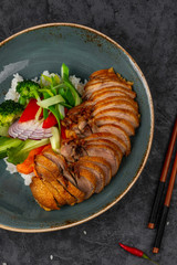 Crispy Asian duck with rice and vegetables.
