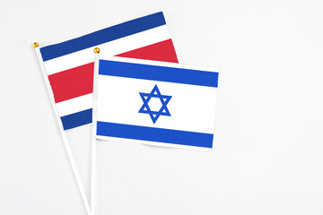 Israel and Costa Rica stick flags on white background. High quality fabric, miniature national flag. Peaceful global concept.White floor for copy space.
