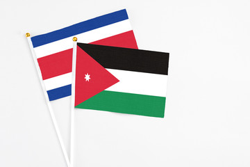 Jordan and Costa Rica stick flags on white background. High quality fabric, miniature national flag. Peaceful global concept.White floor for copy space.