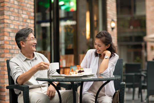 Mature Chinese couple having afternoon tea in coffee shop