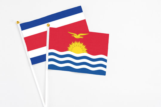 Kiribati and Costa Rica stick flags on white background. High quality fabric, miniature national flag. Peaceful global concept.White floor for copy space.