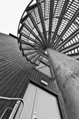 looking up an outdoor spiral staircase - 302543609