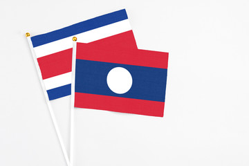 Laos and Costa Rica stick flags on white background. High quality fabric, miniature national flag. Peaceful global concept.White floor for copy space.