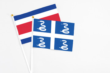 Martinique and Costa Rica stick flags on white background. High quality fabric, miniature national flag. Peaceful global concept.White floor for copy space.