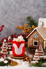 Cup of hot cocoa with marshmallows. Hot chocolate . Gingerbread house and gingerbread christmas trees. Christmas cocoa in fox cup.