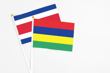 Mauritius and Costa Rica stick flags on white background. High quality fabric, miniature national flag. Peaceful global concept.White floor for copy space.