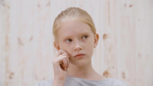 Portrait thoughtful girl teenager looking away on white background in light studio. Close up face pensive girl thinking about something