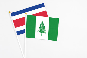 Norfolk Island and Costa Rica stick flags on white background. High quality fabric, miniature national flag. Peaceful global concept.White floor for copy space.