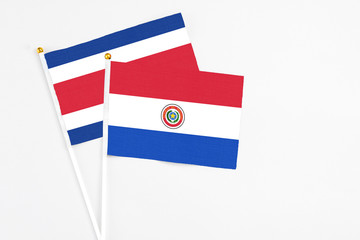 Paraguay and Costa Rica stick flags on white background. High quality fabric, miniature national flag. Peaceful global concept.White floor for copy space.