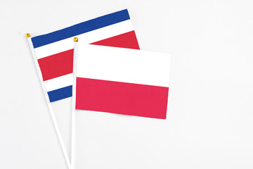 Poland and Costa Rica stick flags on white background. High quality fabric, miniature national flag. Peaceful global concept.White floor for copy space.