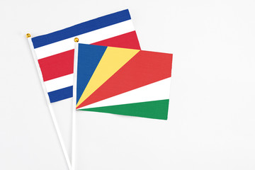 Seychelles and Costa Rica stick flags on white background. High quality fabric, miniature national flag. Peaceful global concept.White floor for copy space.