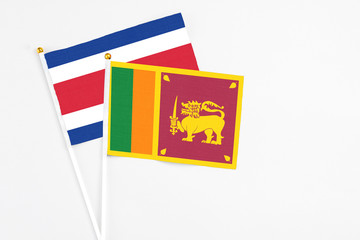 Sri Lanka and Costa Rica stick flags on white background. High quality fabric, miniature national flag. Peaceful global concept.White floor for copy space.