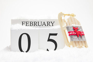 Wooden calendar for February, 5 th day of the winter month. The symbols of winter are snow and...