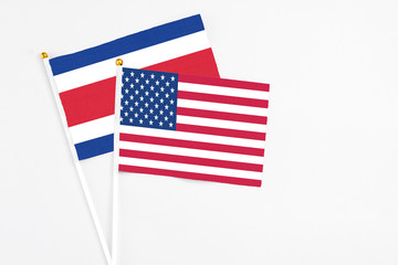 United States and Costa Rica stick flags on white background. High quality fabric, miniature national flag. Peaceful global concept.White floor for copy space.