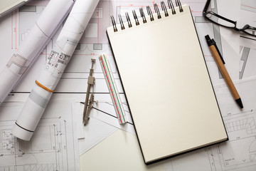 Construction concept. Residential building blueprint drawings and office supplies